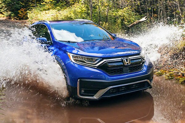 blue Honda Civic hatchback splashing through the water