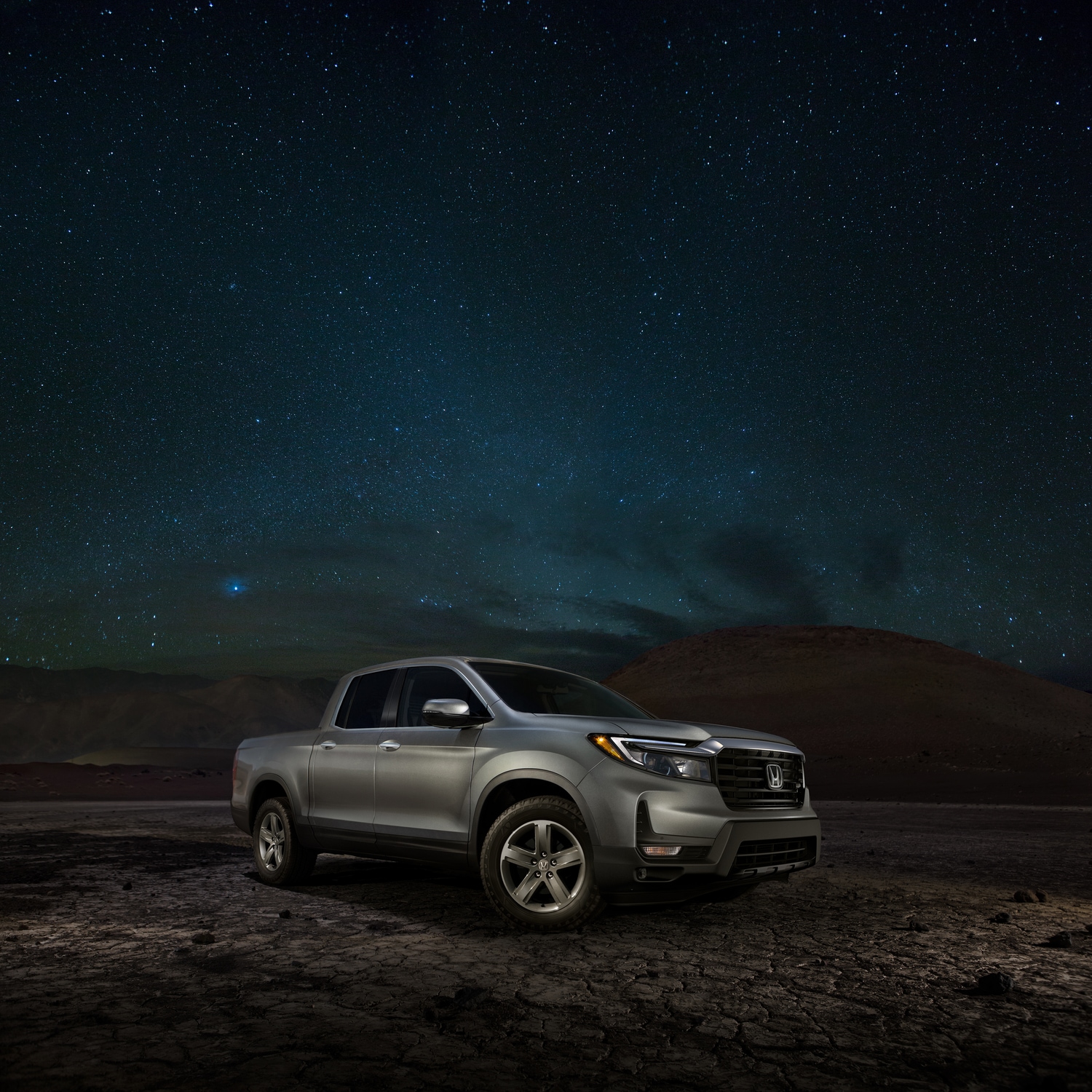 silver Honda Ridgeline truck parked in the desert at night