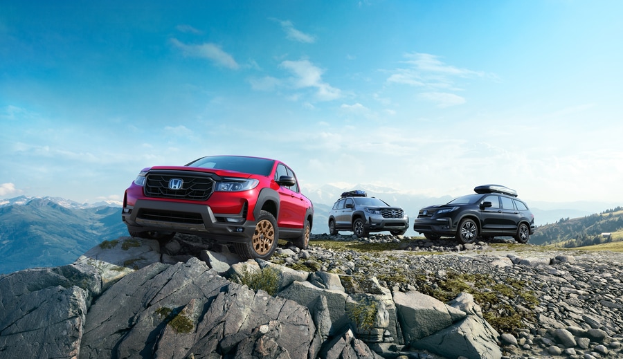 red, grey, and black used Honda models atop a rocky ridge