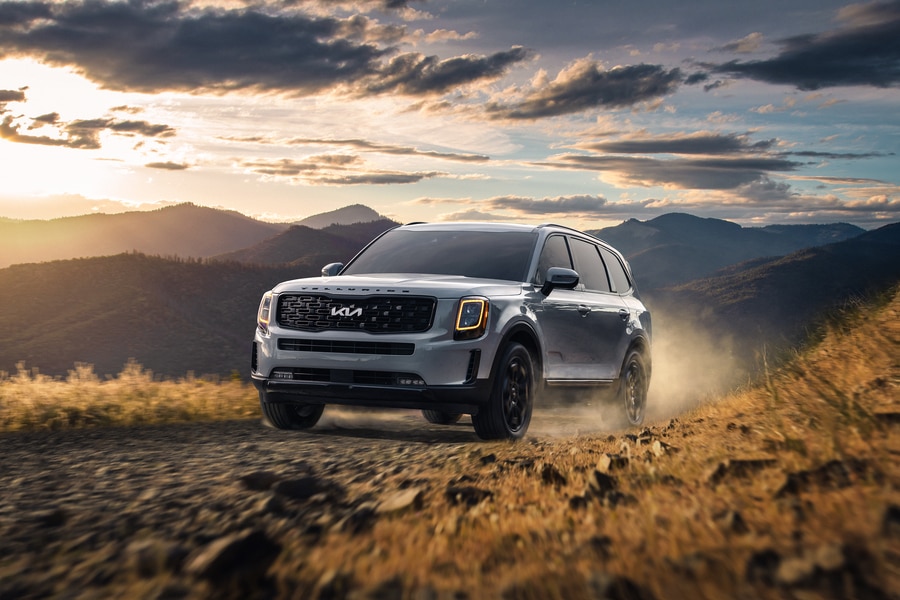 silver Kia SUV driving on a dirt trail