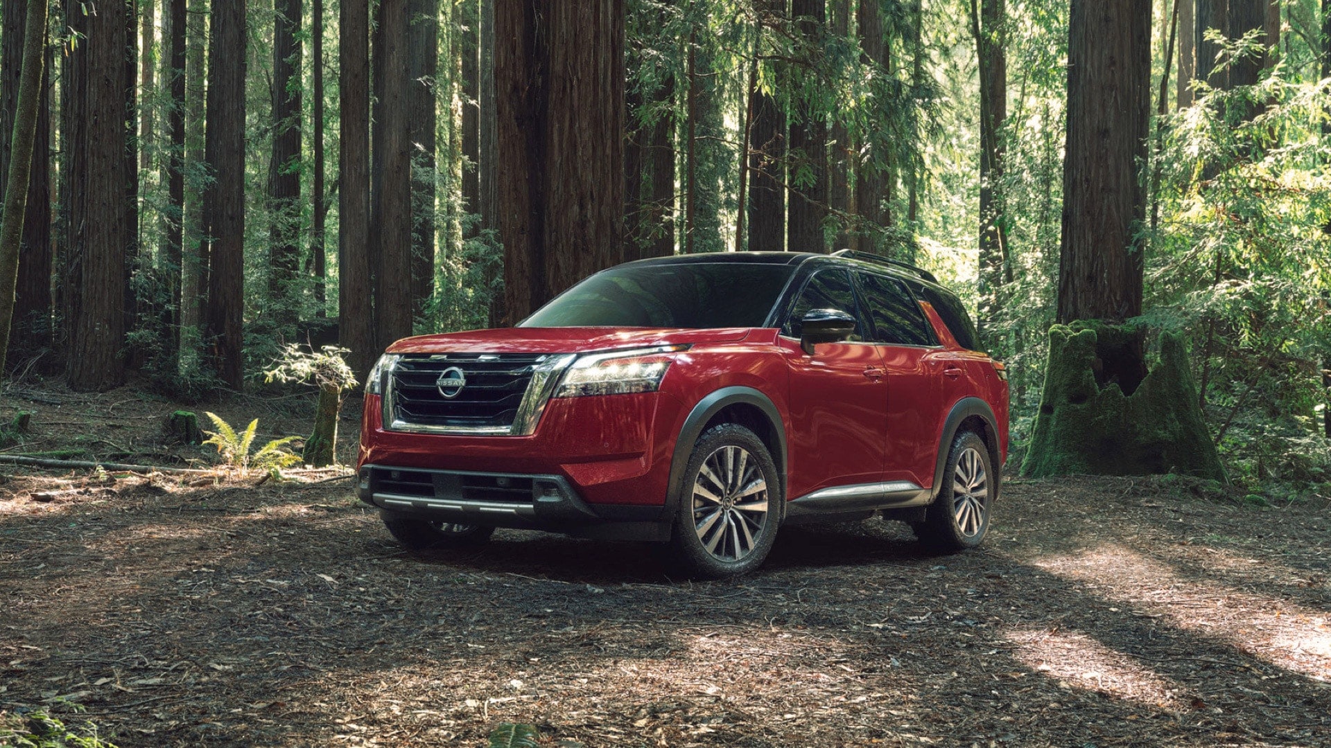 red Nissan SUV parked in the woods