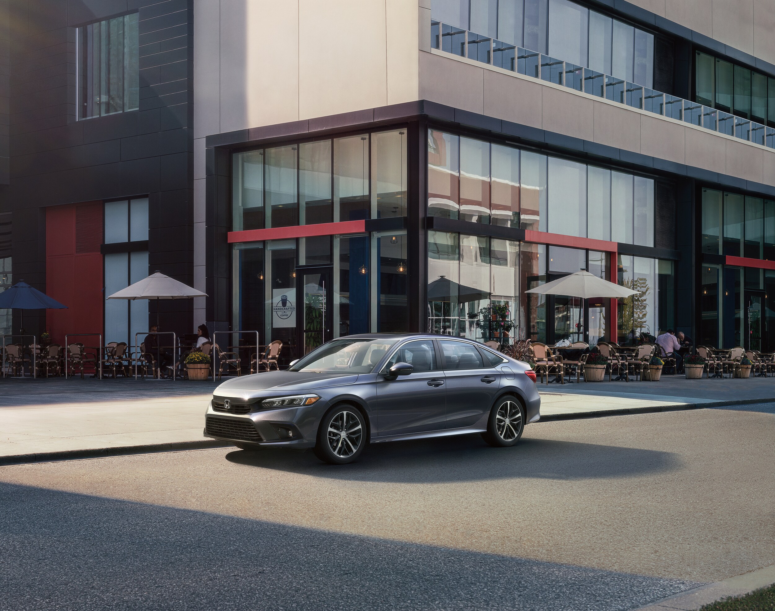 grey Honda Civic touring parked in front of a restaurant