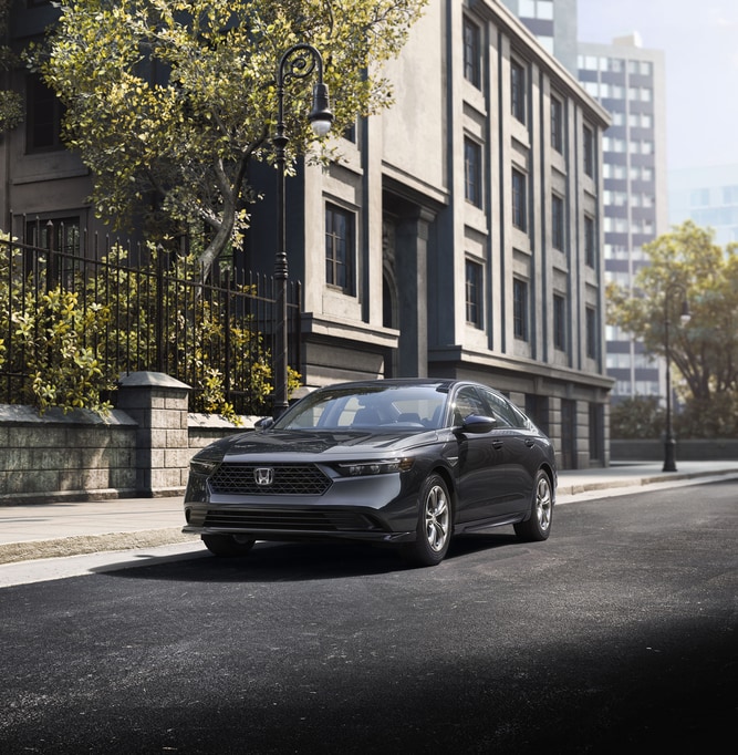 black Honda Accord parked next to a city apartment building