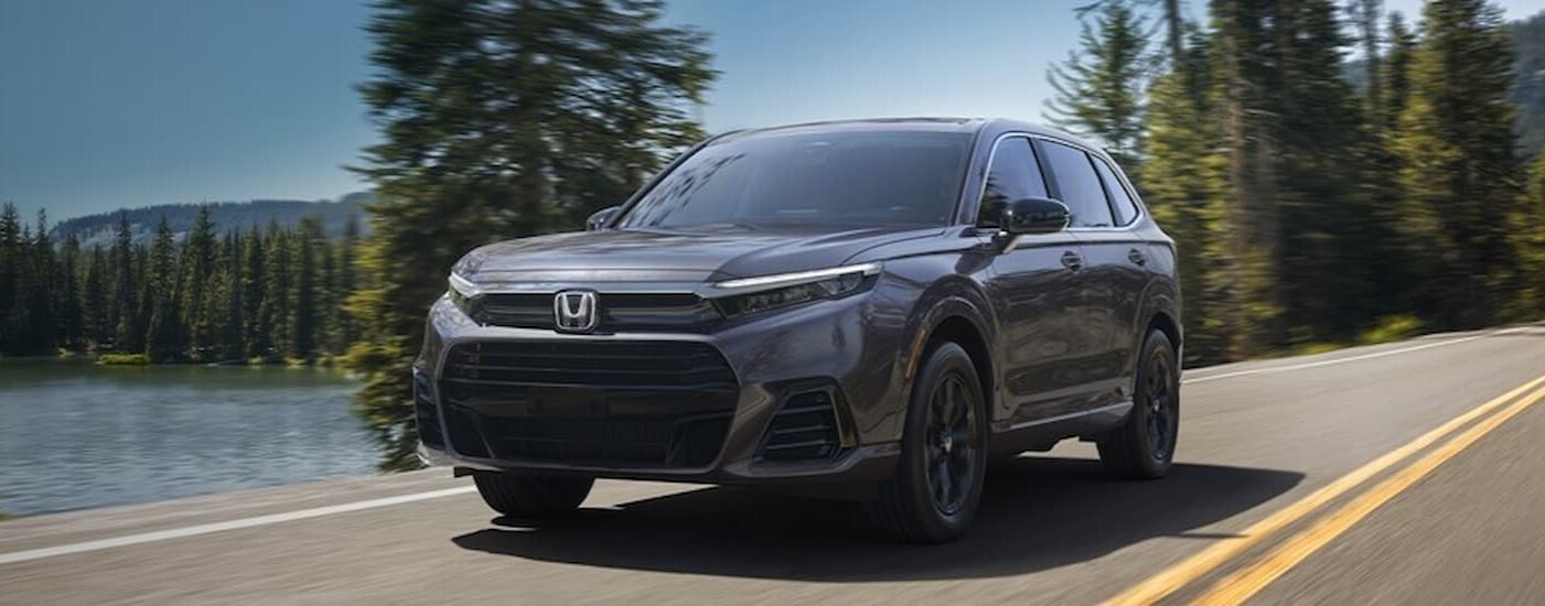 A gray 2025 Honda CR-V for sale near Dearborn is driving on a highway.