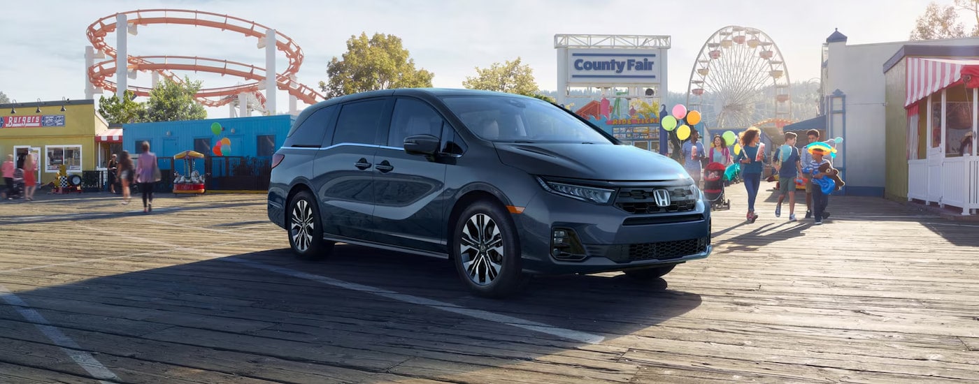 Black 2025 Honda Odyssey parked on a boardwalk.