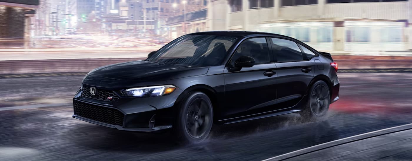 A black 2026 Honda Civic Si driving in a city