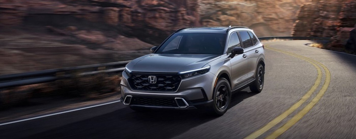 A silver 2023 Honda CR-V driving on a highway.