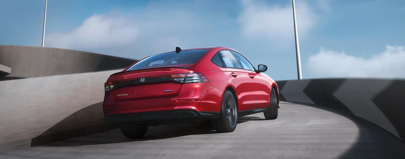 Red 2025 Honda Accord driving on a winding highway