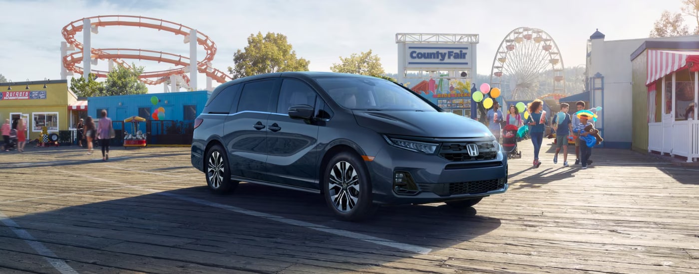 Grey 2026 Honda Odyssey parked in front of a fairground