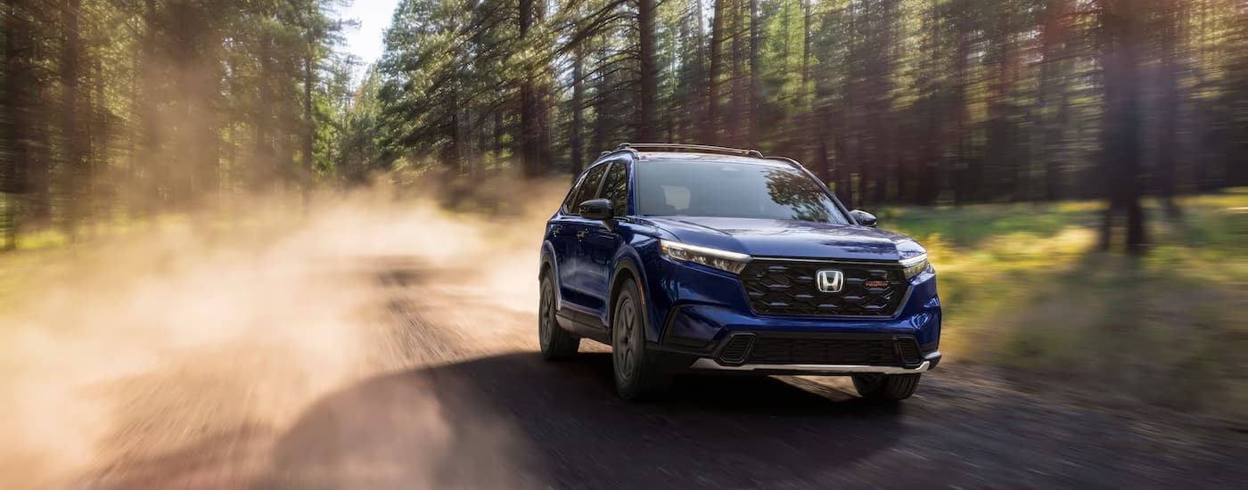 Blue 2025 Honda CR-V driving on a dirt road