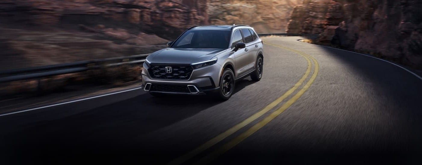 A silver 2025 Honda CR-V driving on a highway.