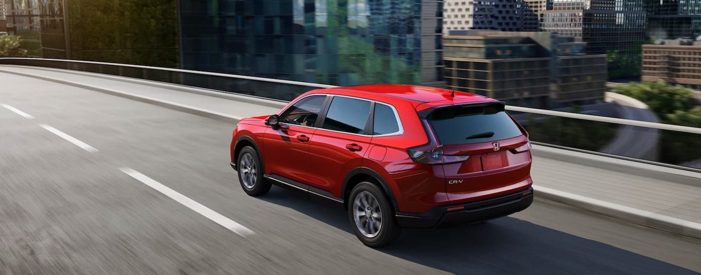 A red 2025 Honda CR-V for sale near Canton driving on a bridge.