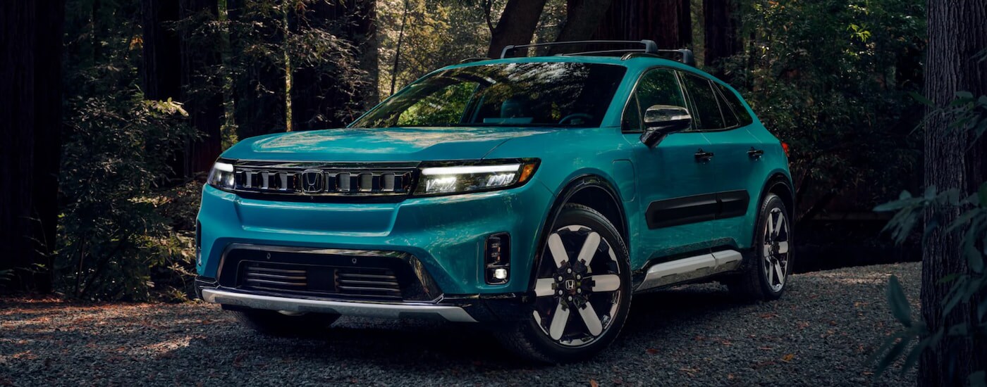 A turquoise 2024 Honda Prologue Elite parked in the woods.