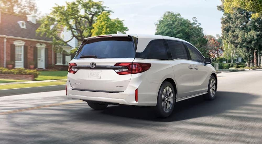 A white 2026 Honda Odyssey driving in a city.