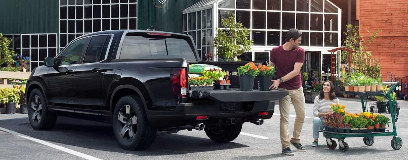 A black 2025 Honda Ridgeline RTL parked at a greenery.