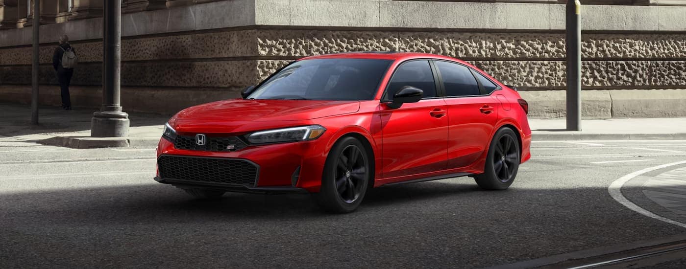 Red 2025 Honda Civic Si for sale near Monroe driving around a bend.