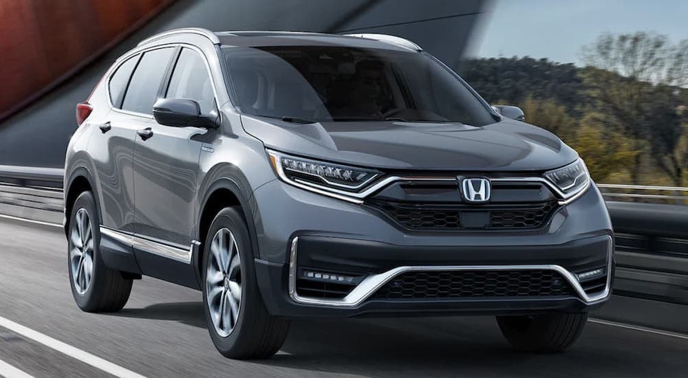 Grey 2022 Honda CR-V Hybrid Touring driving across a bridge.