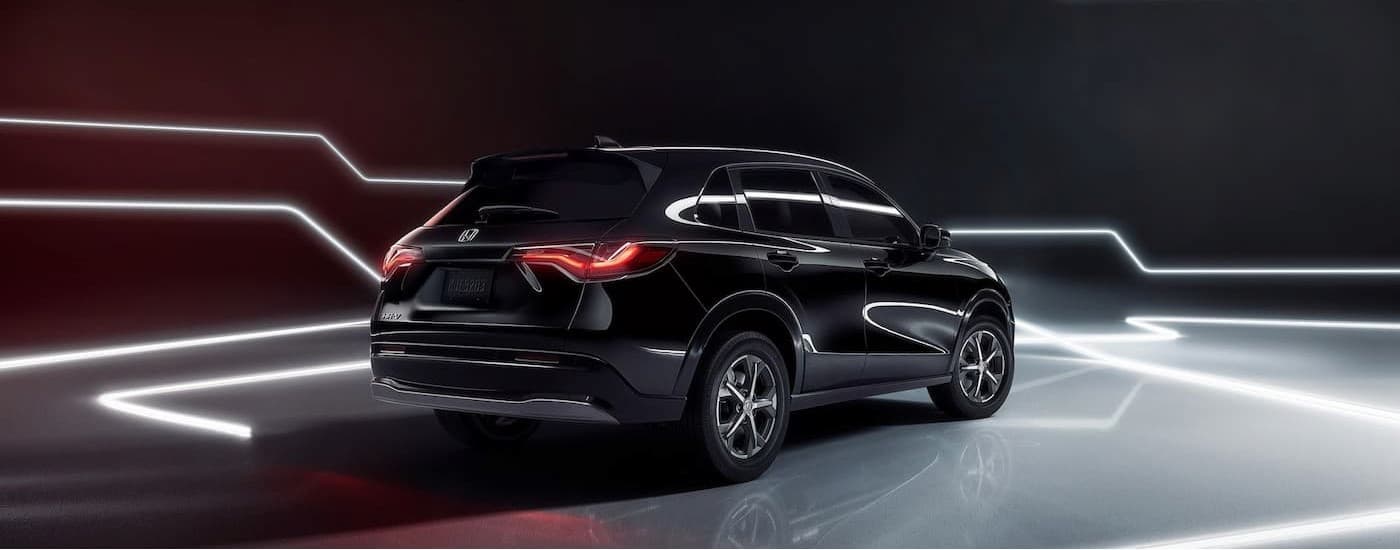 A black 2025 Honda HR-V parked in a simulated showroom.