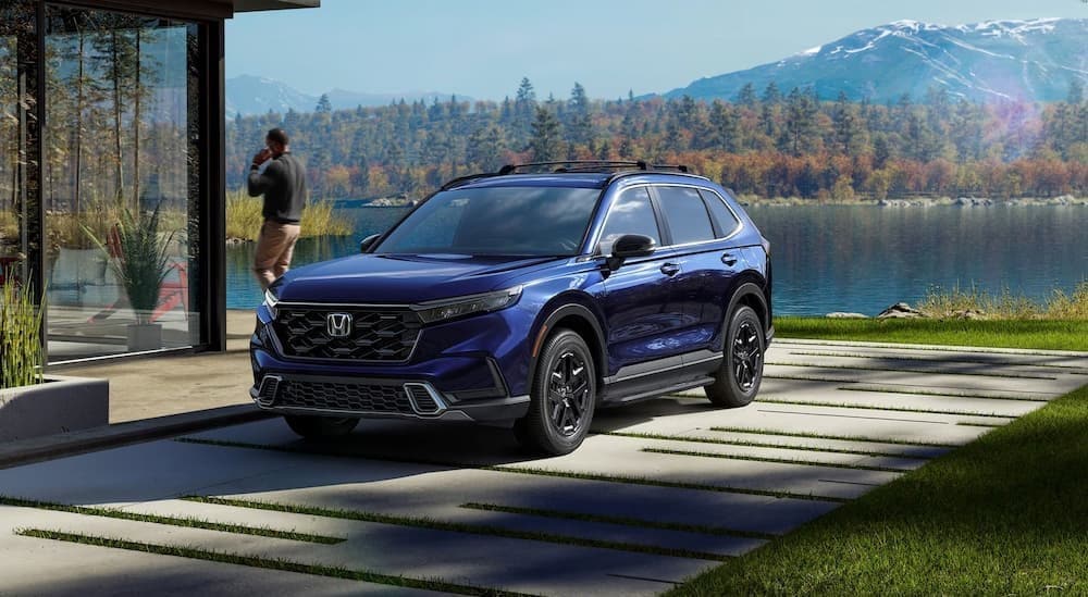 A blue 2025 Honda CR-V parked near a lake.