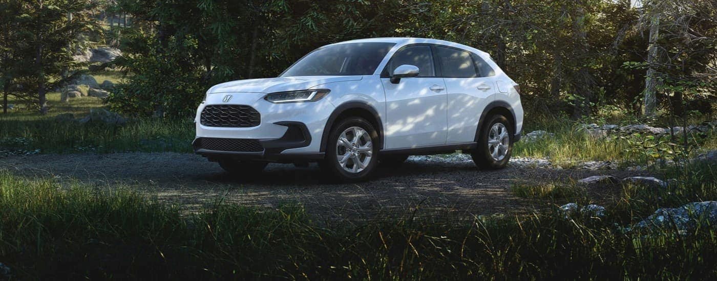 A white 2024 Honda HR-V parked on a clearing in the woods.