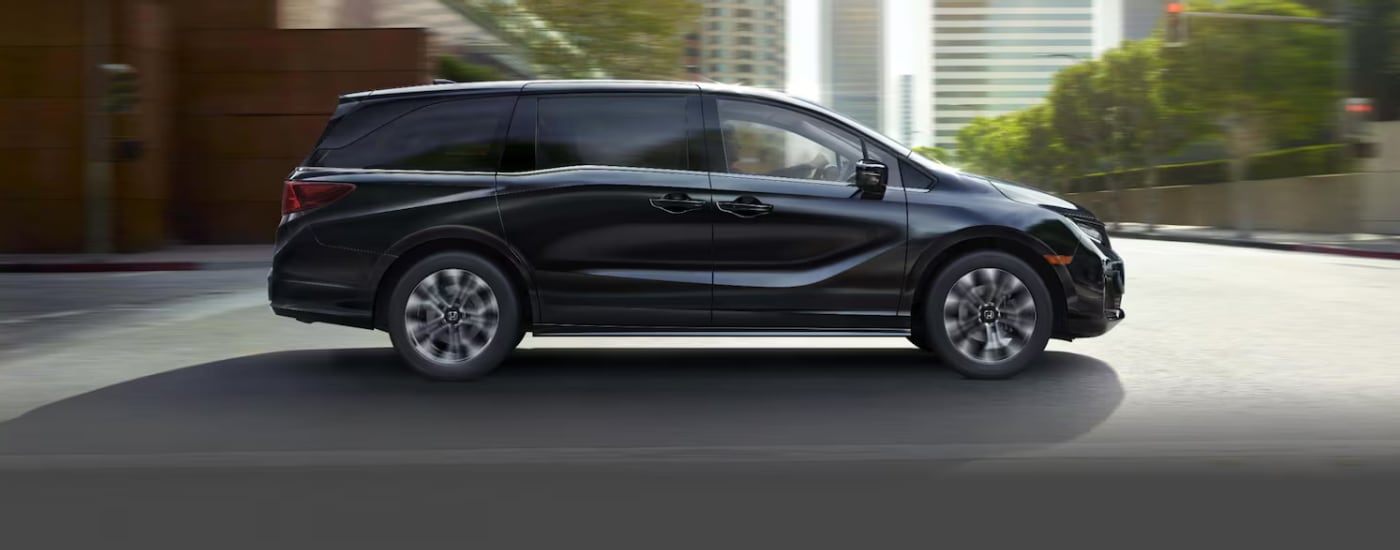 Black 2026 Honda Odyssey driving through a city
