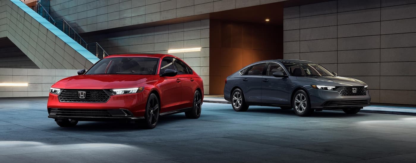 A red and a grey 2025 Honda Accord for sale near Dearborn parked at night