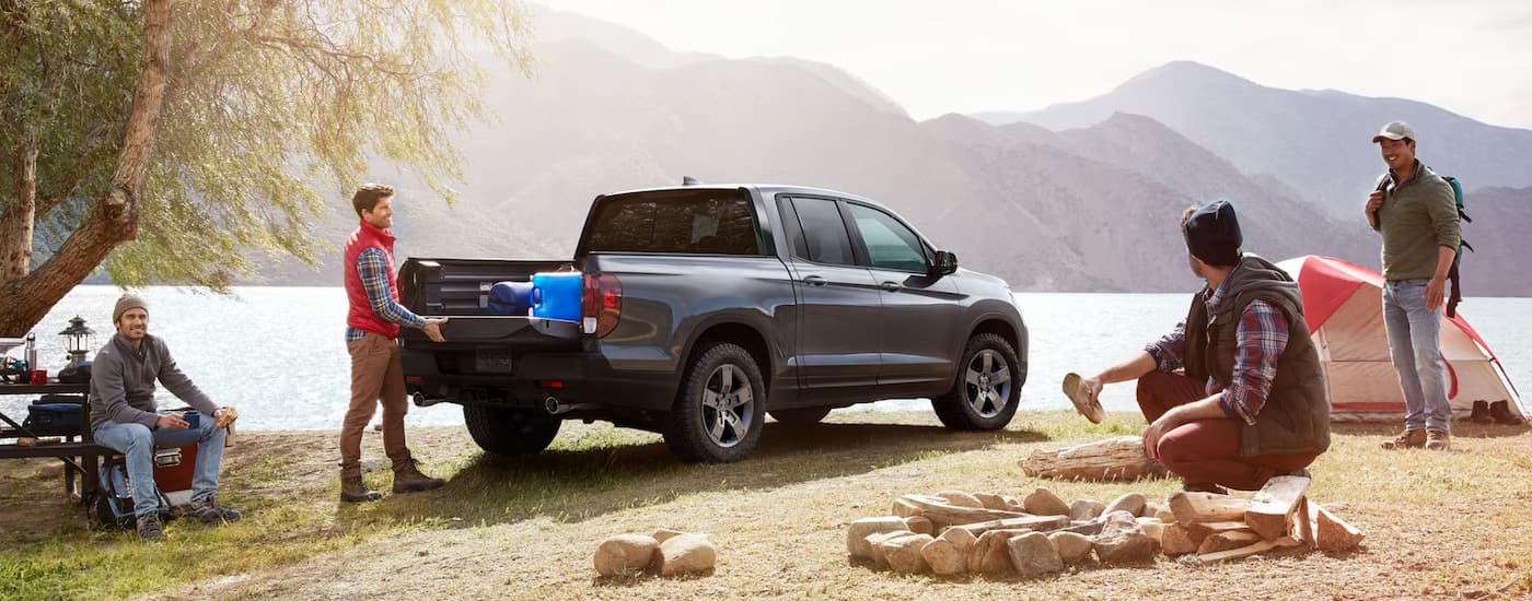A grey 2025 Honda Ridgeline TrailSport parked near a campsite.