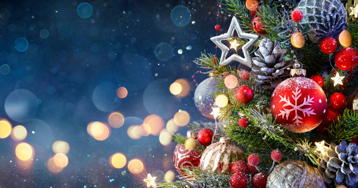 Close-up of a Christmas tree and festive ornaments on a holiday background.