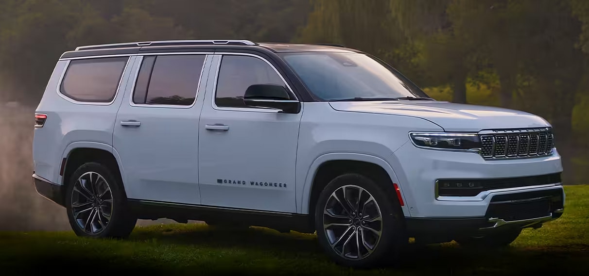 the 2023 Grand Wagoneer is parked on grass with trees in the background
