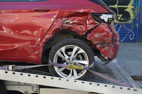 wrecked car being loaded onto a tow truck