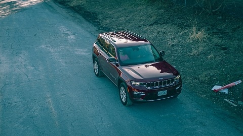 red 2024 jeep grand cherokee SUV parked on the road in plano, tx