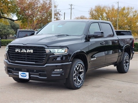 black 2025 RAM 1500 truck parked at the Huffines CDJR Plano dealership in Plano, TX
