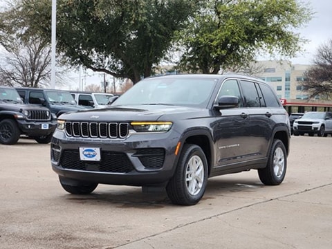 black 2026 Jeep Grand Cherokee parked at the Huffines CDJR Plano dealership in Plano, TX