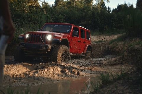 red jeep wrangler SUV on a muddy trail in Plano, tx
