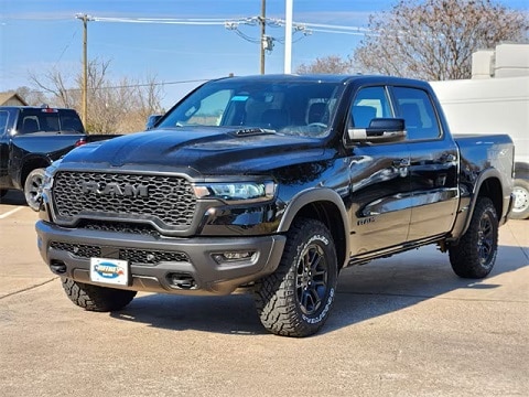 black 2025 RAM 1500 truck parked at the Huffines CDJR Plano dealership in Plano, TX