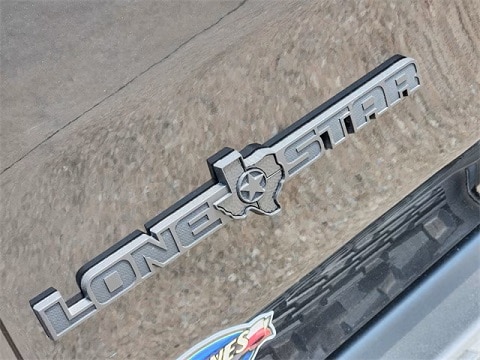 RAM 1500 Lonestar trim emblem on a black 2025 RAM 1500 truck at Huffines CDJR Plano in Plano, TX