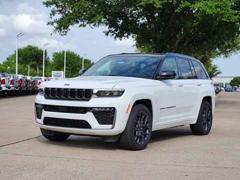 black and white two-tone 2026 Jeep Grand Cherokee parked at the Huffines CDJR Plano dealership in Plano, TX