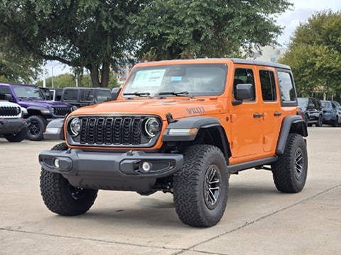 orange 2027 Jeep Wrangler SUV parked at the Huffines CDJR Plano dealership in Plano, TX