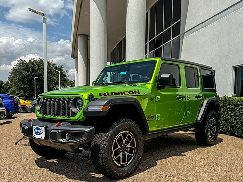 green 2025 Jeep Wrangler SUV parked at the Huffines CDJR Plano dealership in Plano, TX