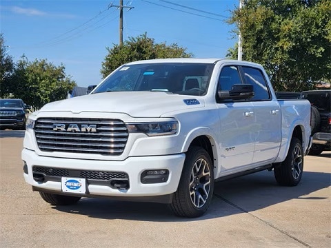white 2025 RAM 1500 truck parked at the Huffines CDJR Plano dealership in Plano, TX