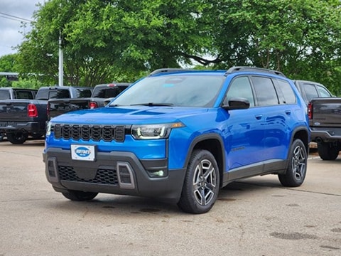blue 2026 Jeep Cherokee SUV parked at the Huffines CDJR Plano dealership in Plano, TX