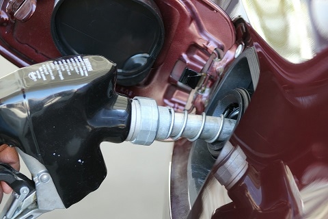 person putting gasoline into their car's fuel tank