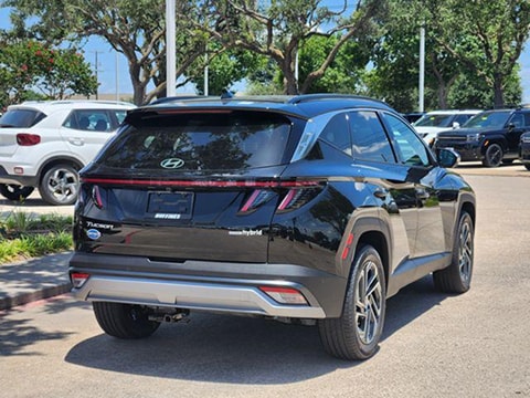 rear view of the 2026 Hyundai Tucson hybrid SUV parked at the Huffines Hyundai Plano dealership in Plano, TX