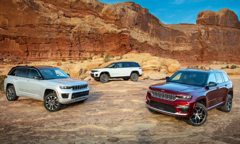 Three 2022 Jeep Grand Cherokees parked in rocky desert