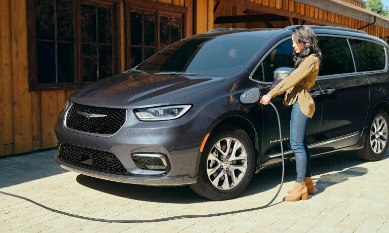 2023 Chrysler Pacifica with woman plugging in charger