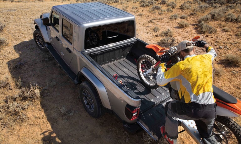 2022 Jeep Gladiator with driver loading bike into bed