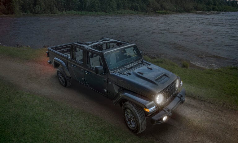 2026 Jeep Gladiator driving by lake with headlights