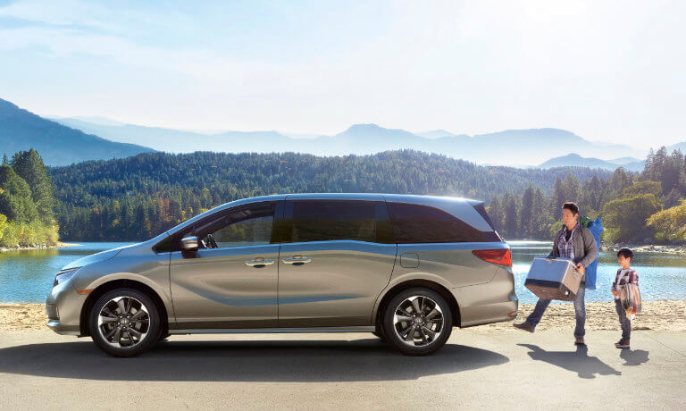 2023 Honda Odyssey parked by a lake with father and son