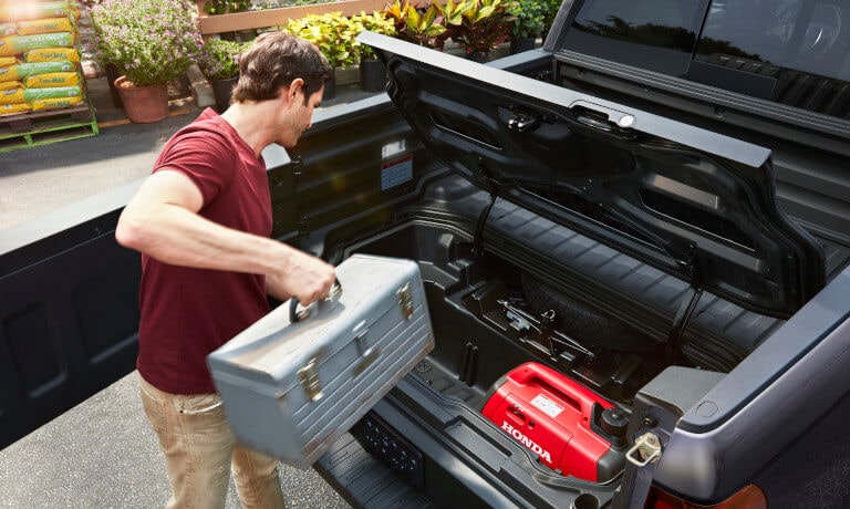 2023 Honda Ridgeline with driver loading cargo into bed