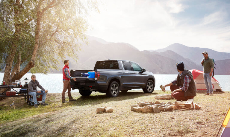 2023 Honda Ridgeline parked at a campsite with campers